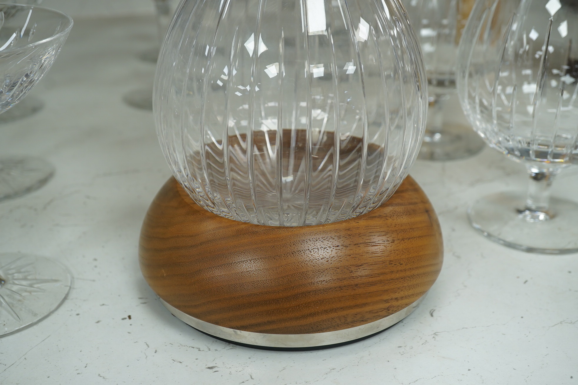 A Linley Glyndebourne pattern cut glass decanter with a silver mounted stopper, on a weighted wooden coaster stand, and a matching set of ten goblets and eight champagne coupes, largest 30cm high. Condition - all in very